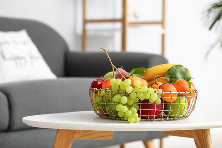 Table with fruit basket in living room, closeupの写真素材