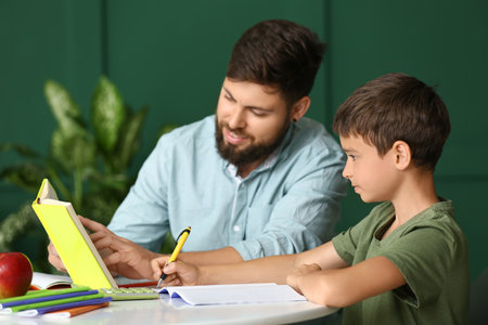 Little boy with his father doing lessons at home