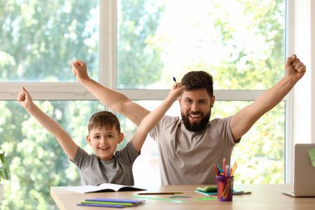 Little boy with his father doing lessons at homeの写真素材
