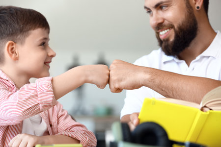 Little boy with his father doing lessons at homeの写真素材