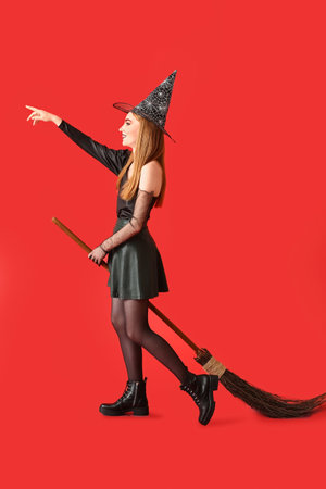 Beautiful woman dressed as witch for Halloween on color backgroundの写真素材