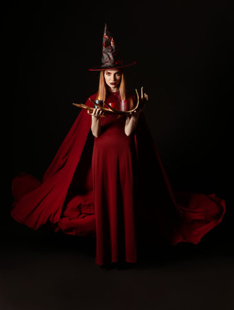 Young witch with candles on dark backgroundの写真素材