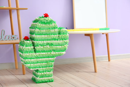 Mexican pinata in shape of cactus in stylish room