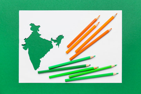 Paper sheet with Indian continent and pencils on color backgroundの写真素材