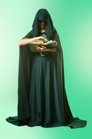 Young witch with spell book on color backgroundの写真素材