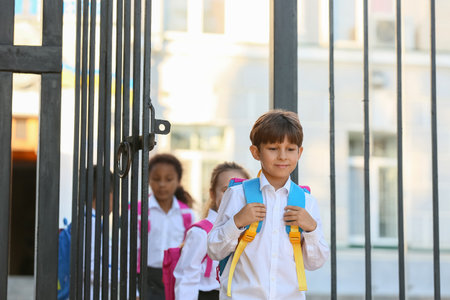 Cute little pupils near school entrance outdoorsの写真素材