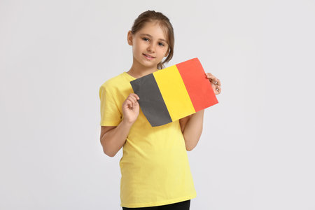 Little girl with flag of Belgium on light backgroundの写真素材