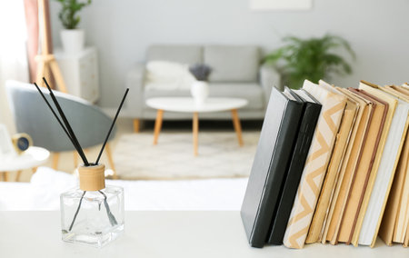Books and reed diffuser on shelf in light room, closeupの写真素材