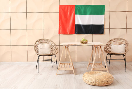 Dining table with apples, chairs and UAE flag hanging on beige wallの写真素材