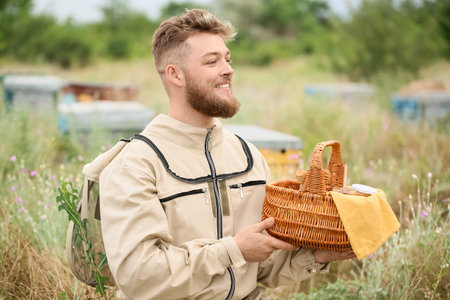 Beekeeper with honey in basket at apiaryの写真素材