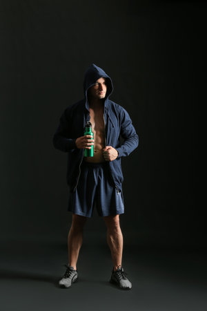 Male bodybuilder with protein shake on dark backgroundの写真素材
