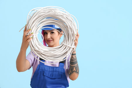 Female electrician with cables on color backgroundの写真素材