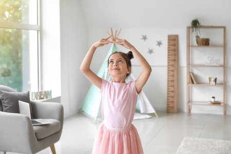 Adorable little ballerina dancing at homeの写真素材