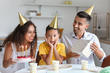 Happy interracial family celebrating birthday at homeの写真素材