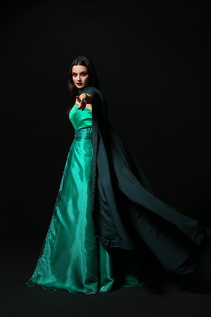 Beautiful woman dressed as witch for Halloween on dark backgroundの写真素材