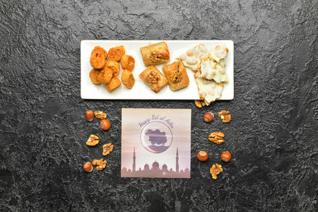 Greeting card for Eid al-Adha (Feast of the Sacrifice) with Turkish sweets on dark background