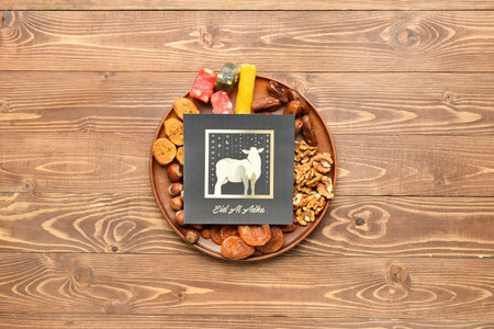 Tray with greeting card for Eid al-Adha (Feast of the Sacrifice) and Turkish sweets on wooden...