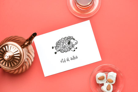 Greeting card for Eid al-Adha (Feast of the Sacrifice) with Turkish tea and sweets on color...