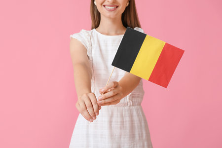 Young woman with flag of Belgium on color backgroundの写真素材