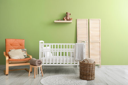 Interior of modern children's room with beautiful crib and comfy armchairの写真素材