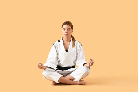 Female karate instructor meditating on color backgroundの写真素材