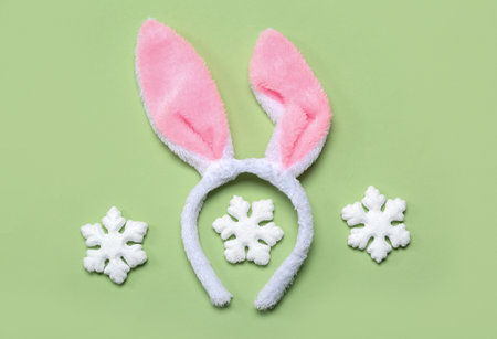 Bunny ears with snowflakes on green background