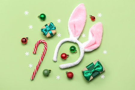 Bunny ears with Christmas decor and gifts on green backgroundの写真素材
