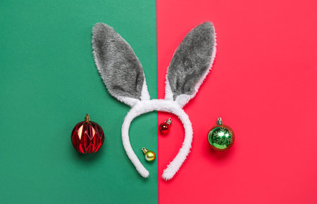 Bunny ears with Christmas balls on green and red backgroundの写真素材