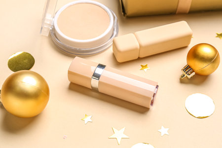 Makeup products with Christmas balls and confetti on beige background, closeupの写真素材