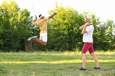 Young men playing badminton outdoors