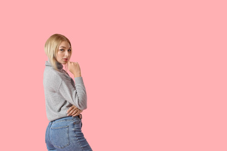 Fashionable young woman in stylish jeans on color background