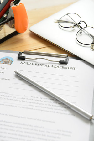 House rental agreement with pen, laptop and eyeglasses on table in office, closeupの写真素材