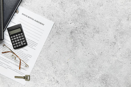House rental agreement with calculator, notebooks, eyeglasses and key on grunge backgroundの写真素材