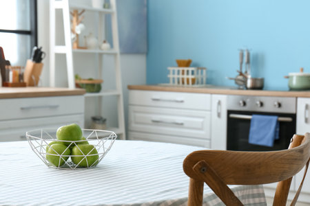 Basket with fresh apples on dining table in kitchenの写真素材