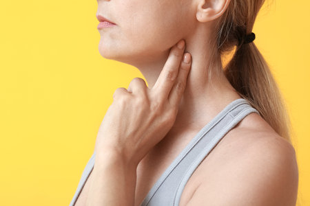 Female runner checking pulse on color backgroundの写真素材