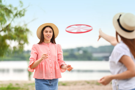 Beautiful young woman playing flying disc outdoorsの写真素材