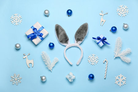 Bunny ears with Christmas decor, fir branches and gifts on blue backgroundの写真素材