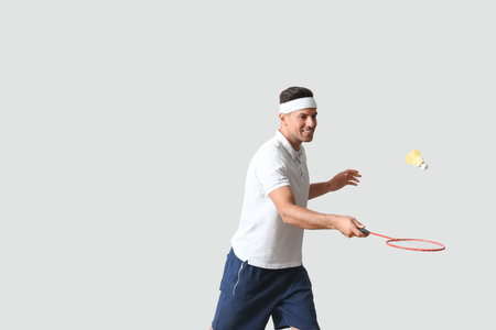 Sporty male badminton player on light backgroundの写真素材