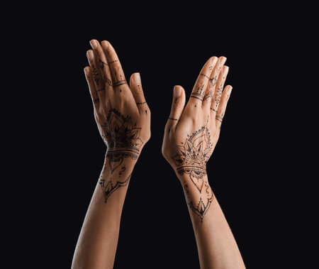 Female hands with henna tattoo on dark backgroundの写真素材