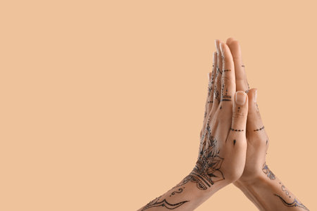 Female hands with henna tattoo on color backgroundの写真素材