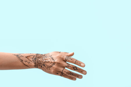Female hand with henna tattoo on color backgroundの写真素材