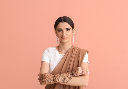 Beautiful Indian woman with henna tattoo on color backgroundの写真素材