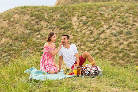 Happy young couple having a romantic picnic in the mountainsの写真素材