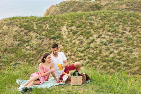 Happy young couple having a romantic picnic in the mountainsの写真素材