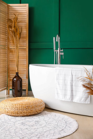 Vase with dry reeds near bathtub in roomの写真素材