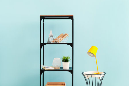 Shelf unit with decor and table with lamp near color wallの写真素材