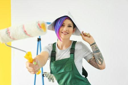 Female painter with roller near color wallの写真素材
