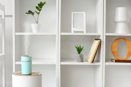 Modern humidifier on table near shelf unitの写真素材