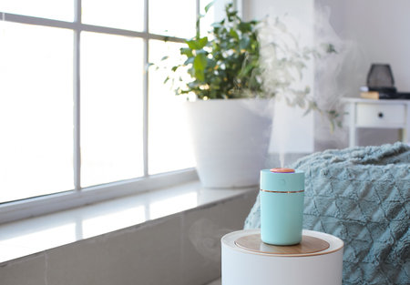 Modern humidifier on table in bedroom