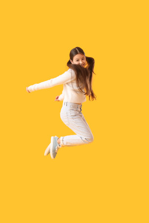 Jumping little girl on color backgroundの写真素材